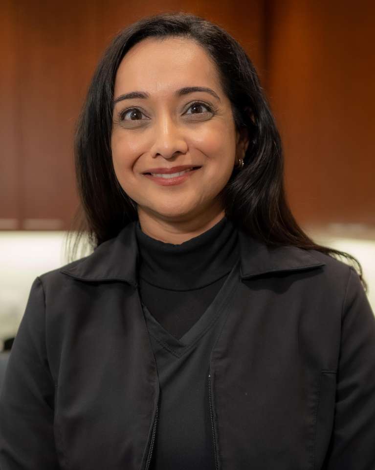 Portrait of Dr. Sandy Hunter wearing a black shirt and smiling into the camera.